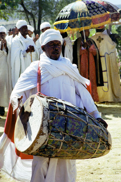 Drumming priest at procession during Timkat. Lalibela. North,  Ethiopia.