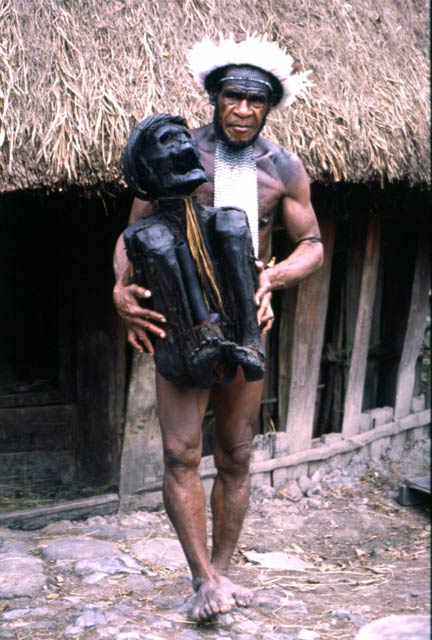 Villager from Dani tribe with 300 years old mummy. Jiwika village. Papua,  Indonesia.